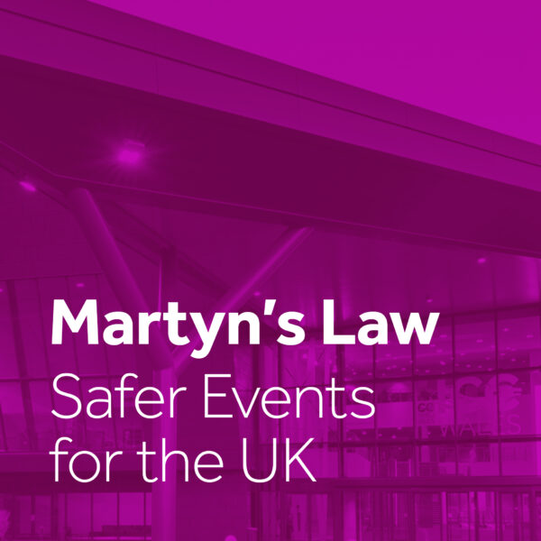 A promotional graphic for Martyn's Law with bold white text stating 'Martyn’s Law - Safer Events for the UK' over a purple-tinted background featuring a modern event venue, emphasizing enhanced security measures for public gatherings.